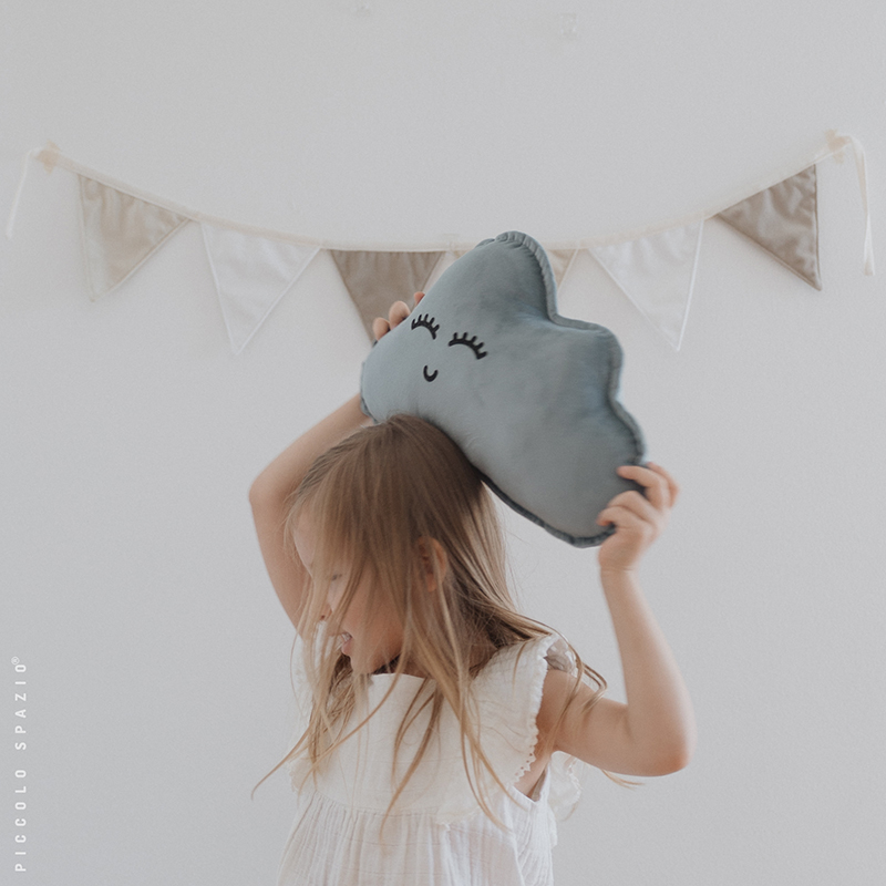 Niña jugando con un cojín en forma de nube azul-Piccolo Spazio