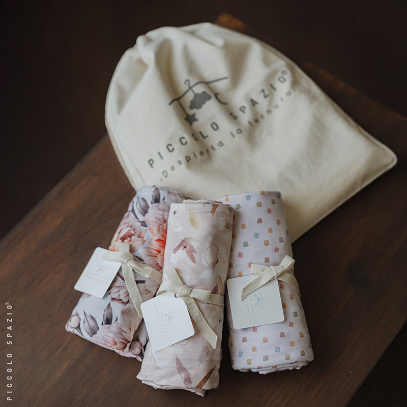 Set de swaddles para envolver bebés de niña sobre una mesa de madera-Piccolo Spaizo