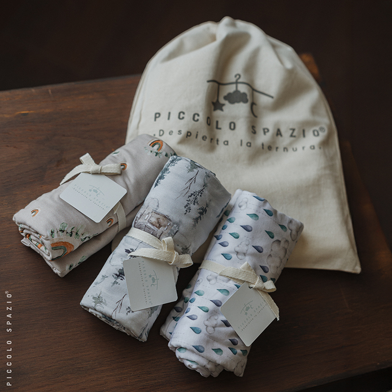 Set de swaddles para envolver bebés de niño sobre una mesa de madera-Piccolo Spaizo
